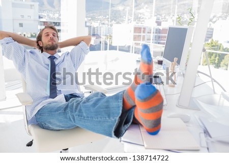 Designer relaxing at desk with no shoes and stripey socks
