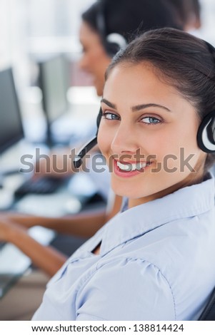 Close up of a call centre agent smiling with her headset
