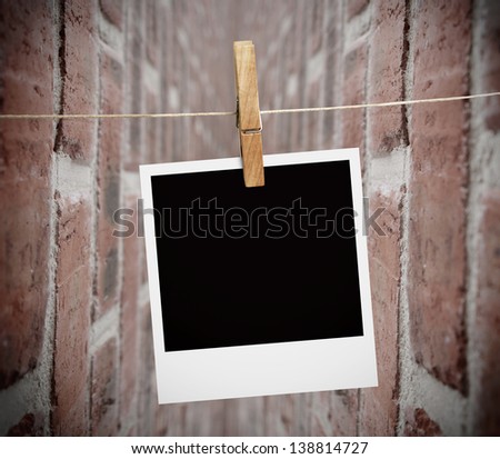Instant print transfer hung with peg with bricks wall on the background