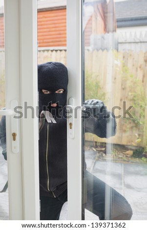 Burglar opening carefully the door with cro bar