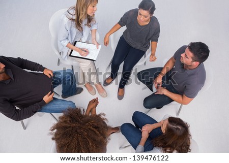 Patients listening to each other in group session sitting in circle