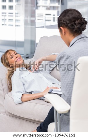 Smiling woman lying on the sofa at a therapist\'s office