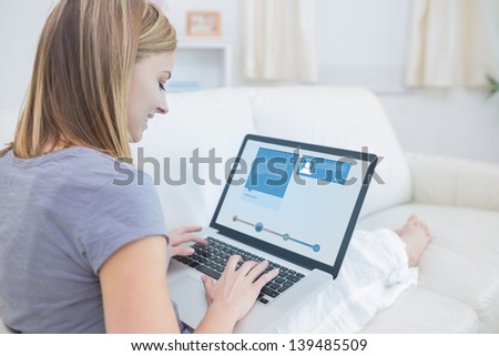 Woman Sitting On Sofa And Checking Her Social Media Profile On The Laptop