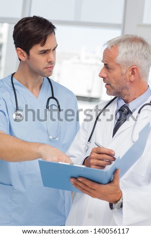 Serious doctors talking about file in hospital