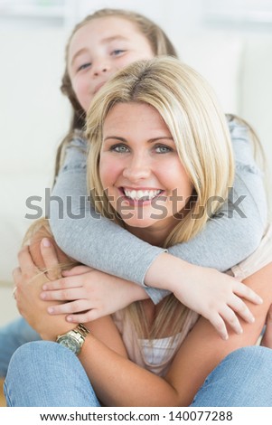 Daughter hugging mother from behind and laughing