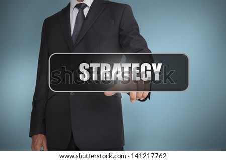 Businessman touching the word strategy written on black tag on blue background