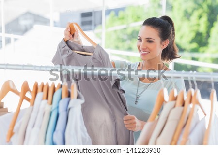 Fashion woman choosing dress in a studio