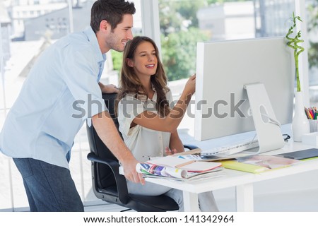 Two photo editors working on a computer in their office