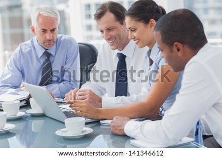 Business people looking at a laptop during a meeting
