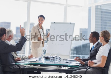 Colleagues Asking A Question To A Businesswoman During A Presentation