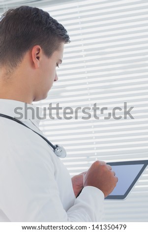 Young doctor using tablet pc in a bright office