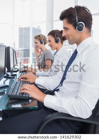 Group of call center employees working in line in a bright office