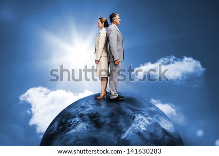 Busines people standing back to back on top of the world in blue sky with sun