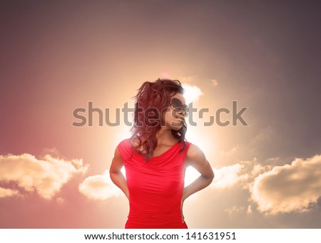 Attractive brunette relaxing under the sun with sunny sky on the background