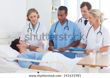 Serious medical team around the bed of a patient