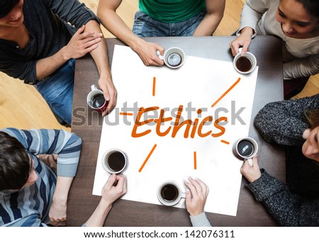 Team brainstorming over a poster on a table with ethics written on it