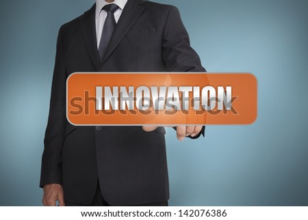 Businessman selecting the word innovation written on orange tag on blue background