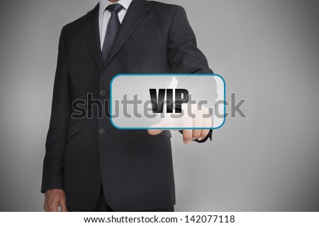 Businessman selecting tag with vip written on it on grey background
