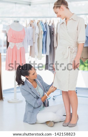 Fashion designer adjusting dress on a model