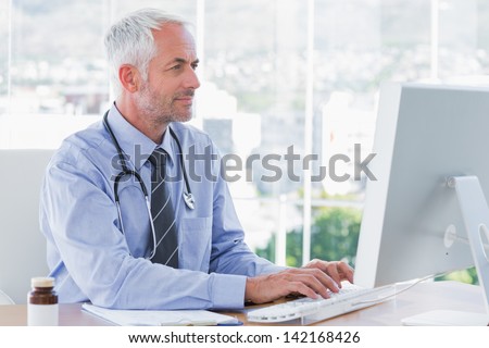 Doctor typing on his computer in the office