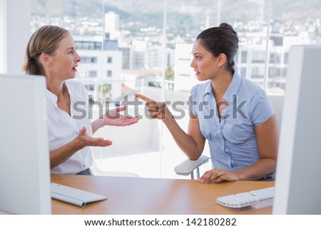 Businesswomen arguing at their desk in the office