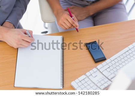 Business people working with notepad at desk overhead shot