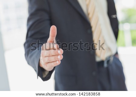 Businessman extending hand for handshake in the office
