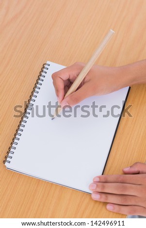 Woman with a pencil drawing on a paper on a desk