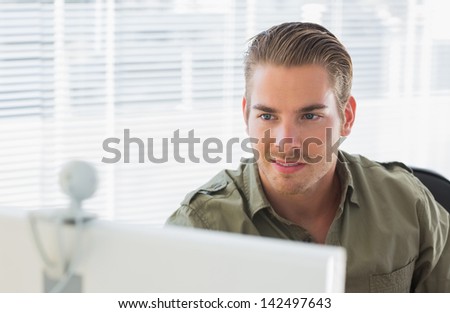 Creative business employee smiling during a videocall in a modern office