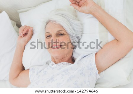 Mature woman waking up in bed