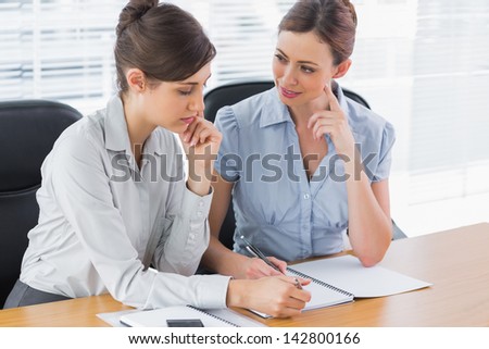 Happy businesswomen working together at desk in office