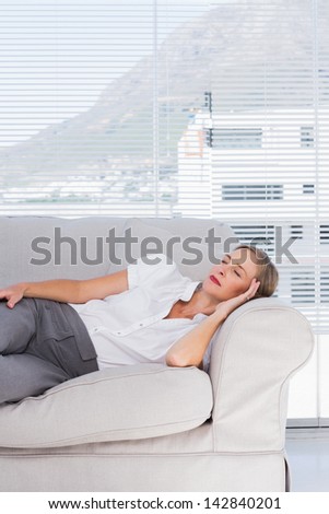 Relaxed businesswoman lying on couch in the office