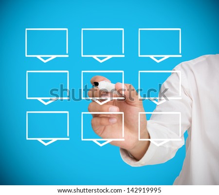 Businessman drawing a grid of white rectangles on blue background