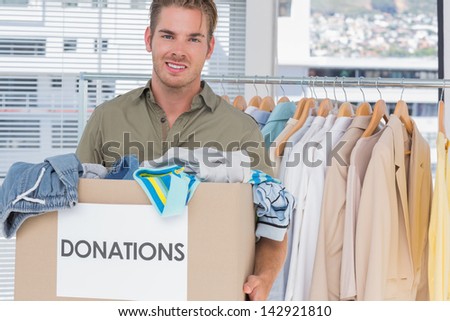 Handsome man holding a clothes donation box