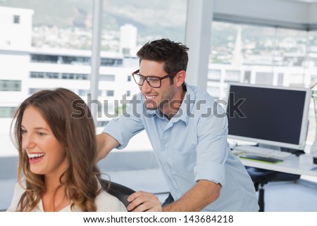 Smiling designers playing on a swivel chair in their office