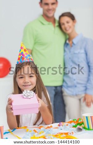 Little girl holding a birthday gift during her birthday