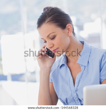Businesswoman calling with her mobile phone in the office