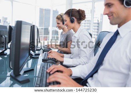 Group of call center agents working in line in a bright office