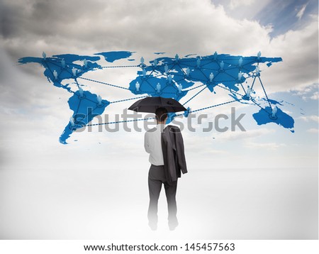 Businessman with an umbrella looking at a world map with blue sky on the background