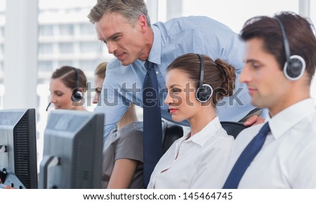 Manager Helping Call Centre Agent On A Computer