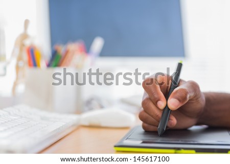 Close up of graphic designer using graphics tablet in a modern office