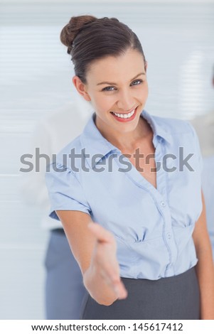 Business woman giving her hand for handshake in office