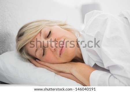 Blonde woman sleeping peacefully at home in bed