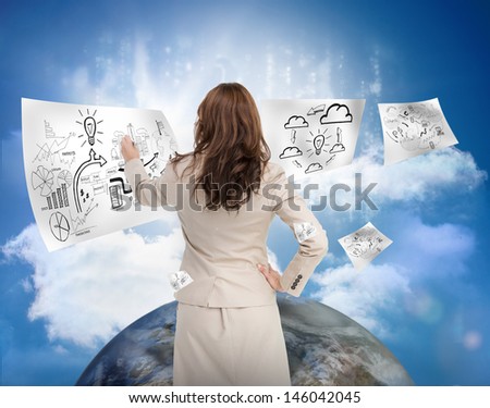 Businesswoman drawing on a floating sheet with planet and blue sky on the background