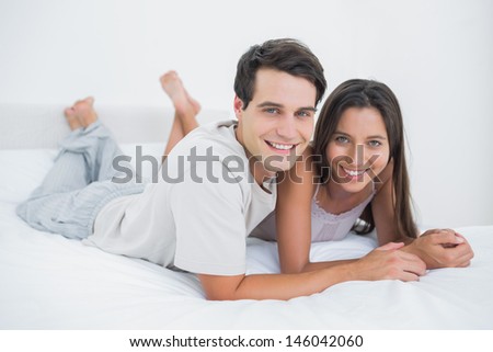 Young couple lying together in bed in the bedroom