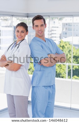 Cheerful medical staff standing with arms folded
