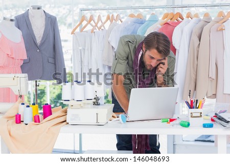 Fashion designer using laptop and calling