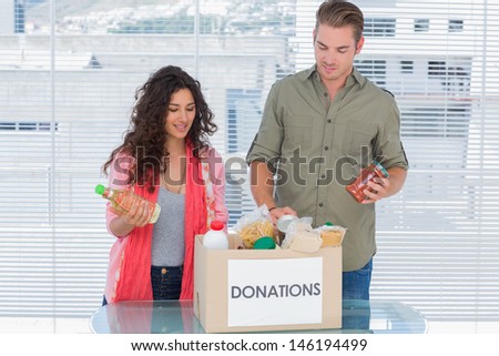 Volunteers taking out food from donations box for a charity