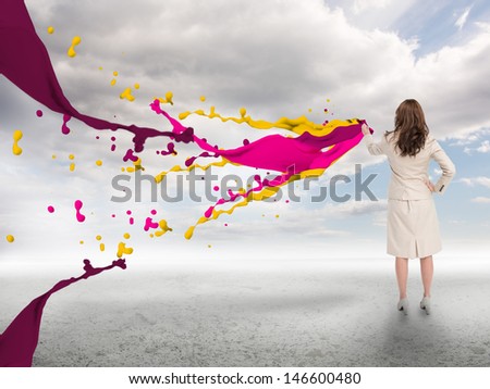 Creative businesswoman with paints splash and blue sky on the background