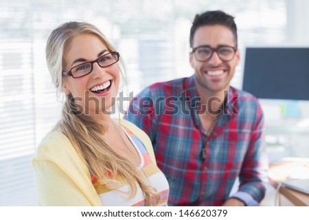 Pair of smiling designers sit in their office
